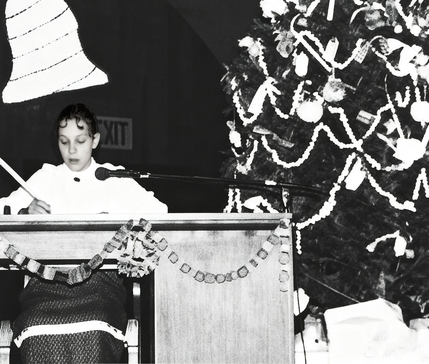 A student reads at the podium beside the Christmas tree