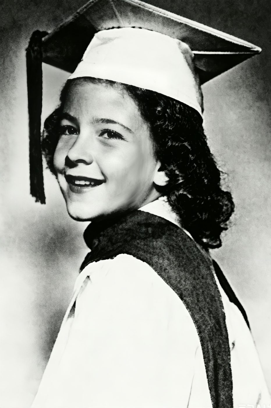 A young graduate in cap and gown