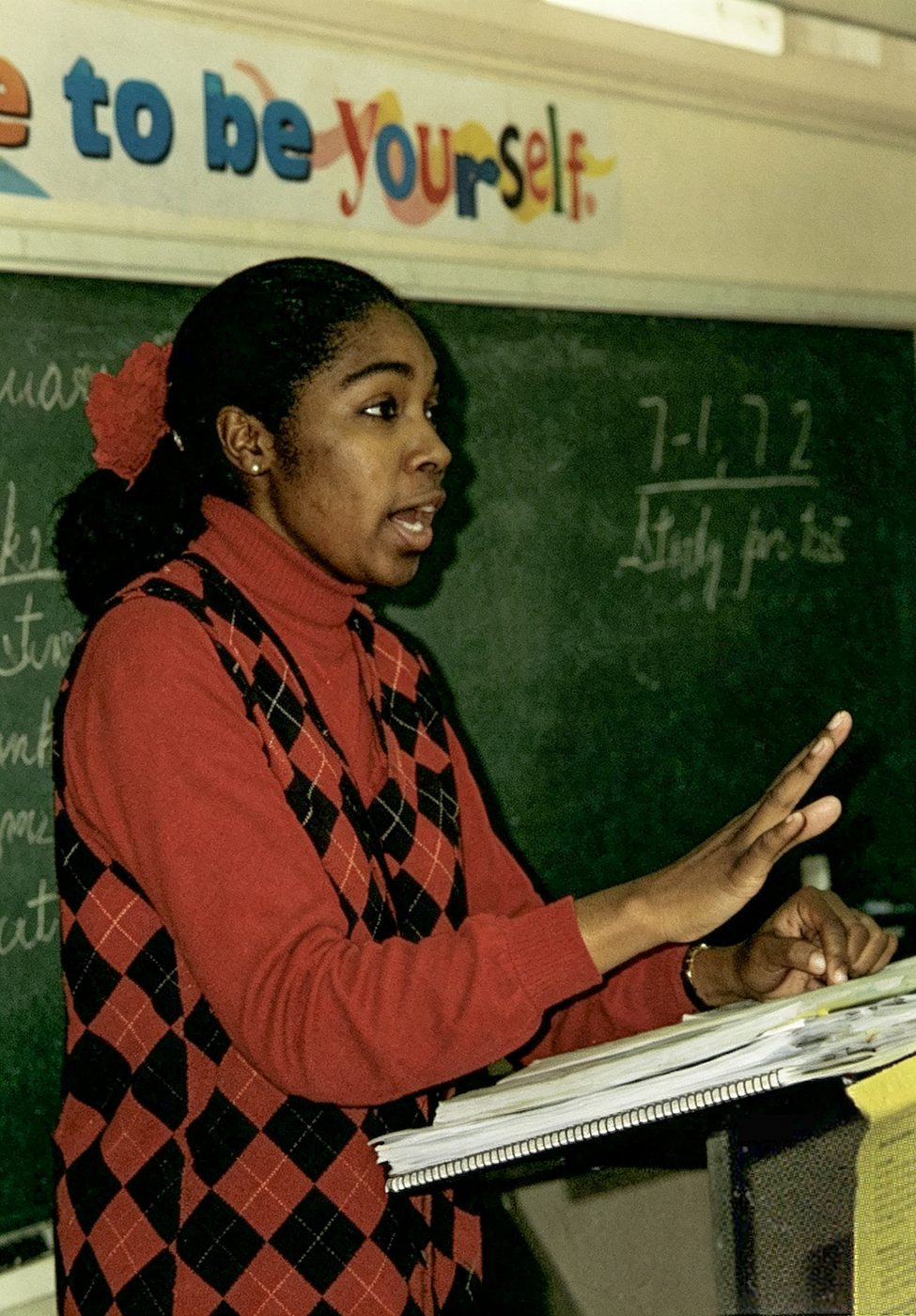 A teacher writes on the chalkboard